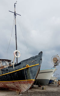 Low angle view of fishing boats in sea against sky