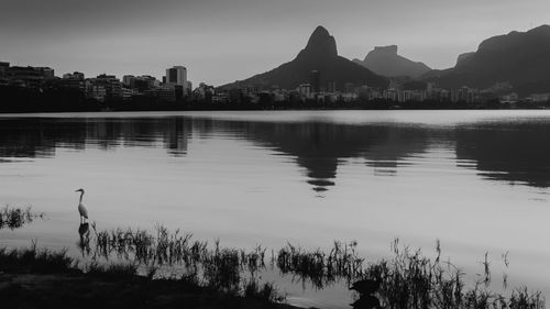 Scenic view of lake by city against sky