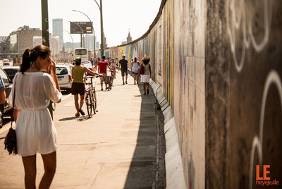 Rear view of people walking on street in city