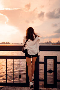 Rear view of woman looking at sea against sky