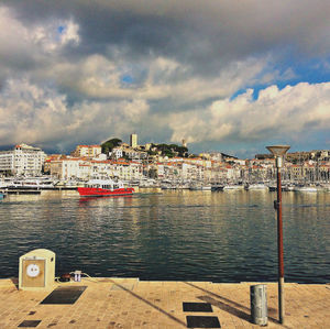 Scenic view of sea by buildings in city against sky