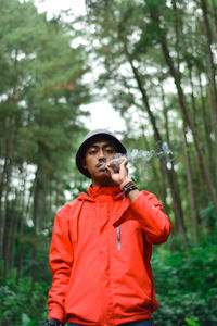 Full length of young man standing in forest