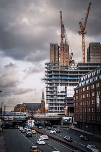 View of cityscape against cloudy sky