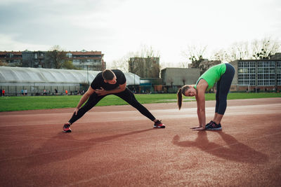 Young couple exercising on sports track