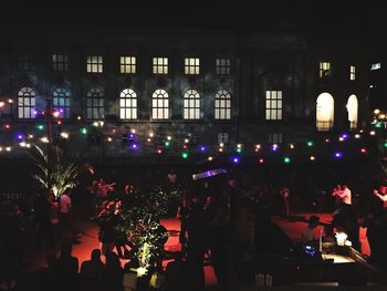People in illuminated building at night