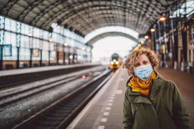 Portrait of woman standing on railroad station platform