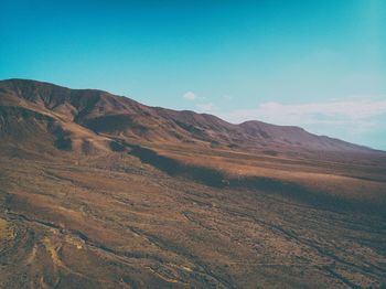 Scenic view of mountains against blue sky