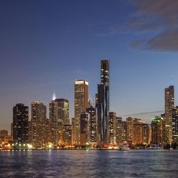 Illuminated buildings in city against sky