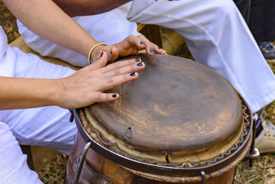 Midsection of woman playing drum outdoors