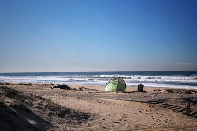 Scenic view of beach against clear blue sky