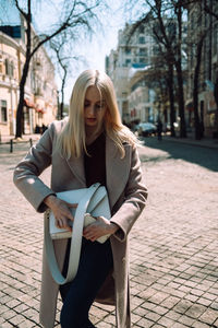 Young woman wearing bag on street in city