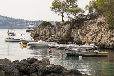 Sailboats moored on sea against sky