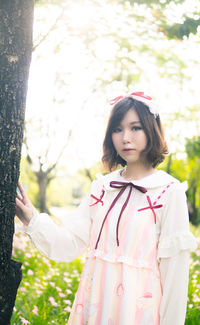 Portrait of a girl standing on tree trunk