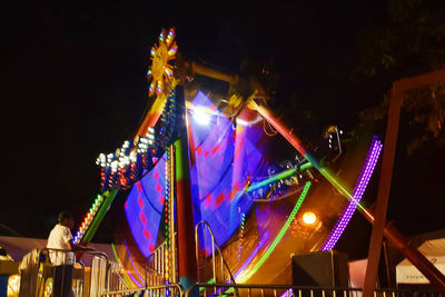 Low angle view of illuminated ferris wheel at night