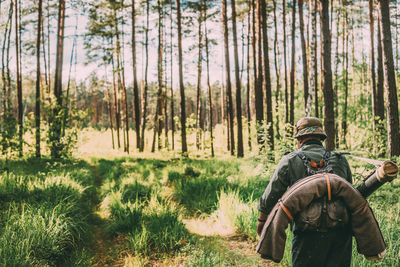 Rear view of soldier walking on trail in forest