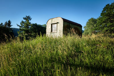 Abandoned building on field against clear sky