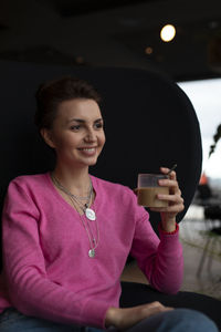 Young woman using mobile phone while sitting in car