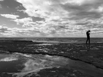 Man standing on beach against sky