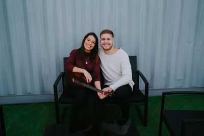 Portrait of young couple sitting on seat