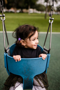 Little girl sitting in swing smiling