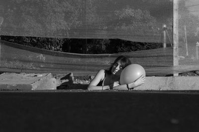 Woman with balloon relaxing at construction site