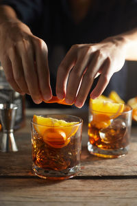 Midsection of woman drinking glass on table