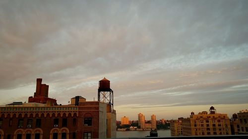 View of cityscape against cloudy sky