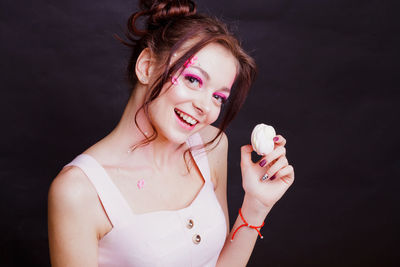 Close-up of young woman against black background