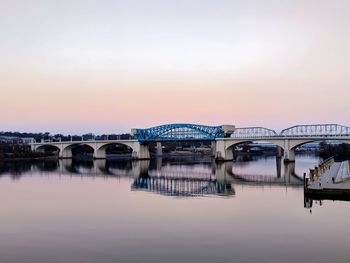 Bridge over river against sky during sunset