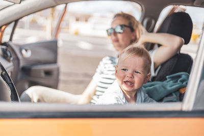 Portrait of young woman sitting in car