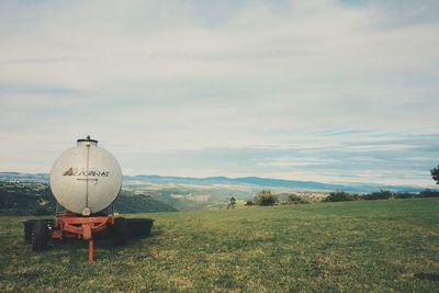 Scenic view of field against cloudy sky