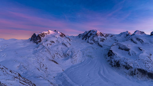 Scenic view of snowcapped mountains against sky during sunset