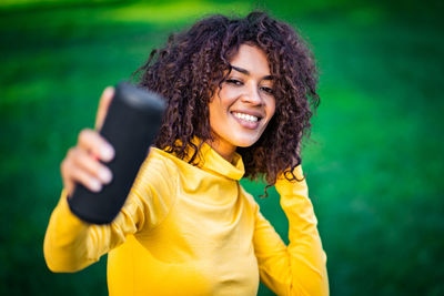 Portrait of smiling young woman using mobile phone