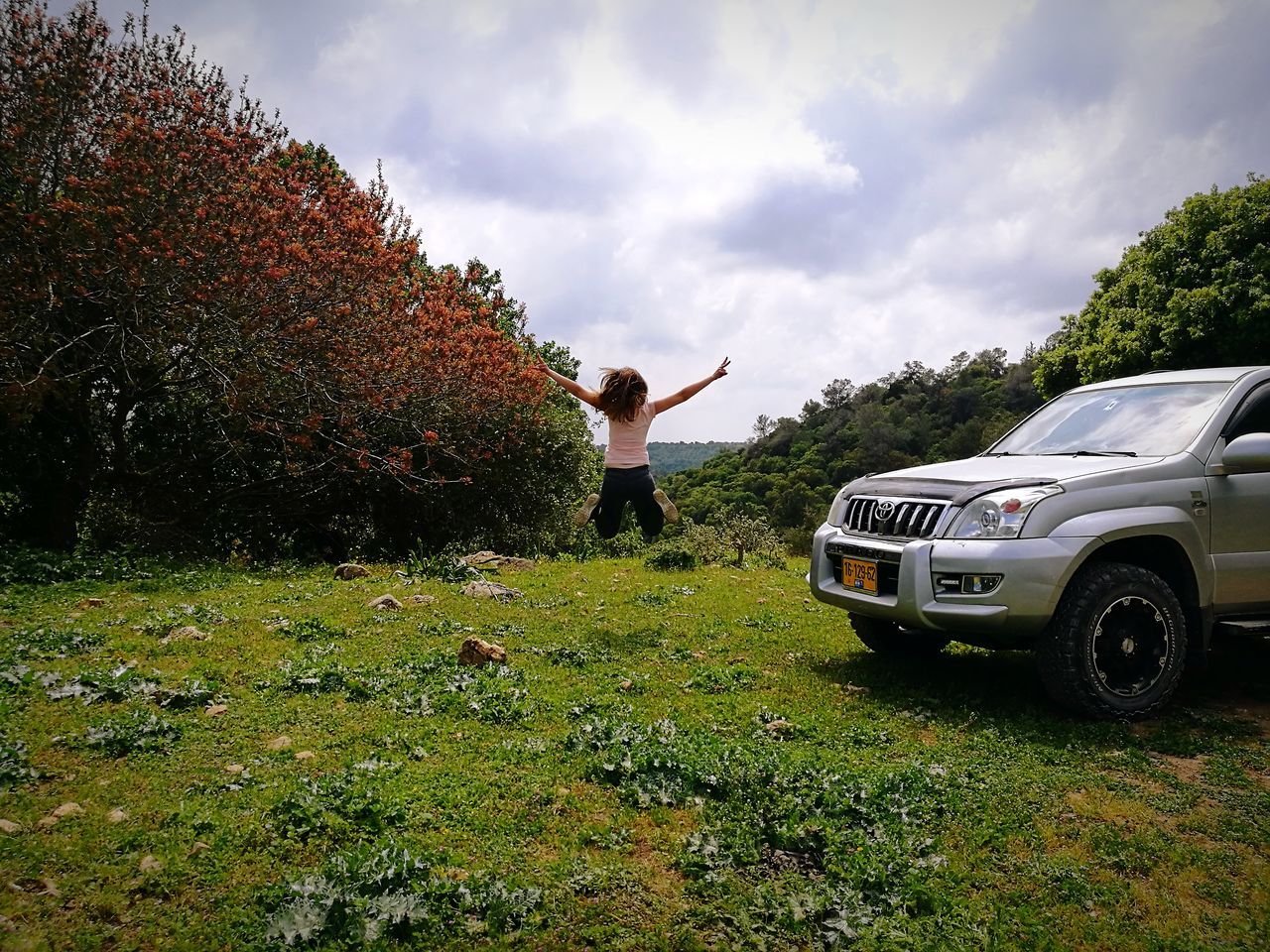 plant, one person, real people, car, nature, cloud - sky, motor vehicle, sky, day, full length, mode of transportation, transportation, tree, field, standing, land vehicle, lifestyles, growth, leisure activity, human arm, outdoors, arms raised, teenager, human limb