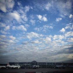 Boats in sea against cloudy sky