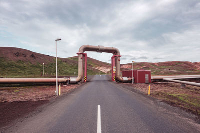 Road leading towards bridge against sky