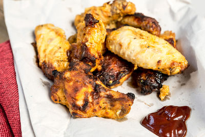 Close-up of chicken wings with sauce on folded fabric