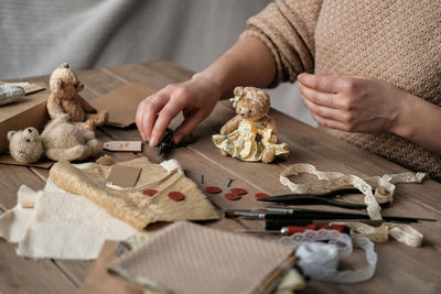 A young woman sews a teddy bear. hobby