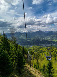 Scenic view of overhead cable car against sky
