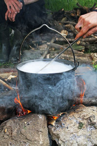 High angle view of people cooking food on fire at campsite