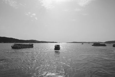 Boats in calm sea against sky