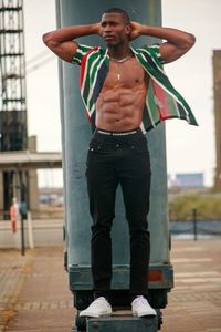 Rear view of man with arms raised standing in city