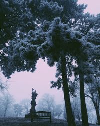 Statue in park against sky during winter