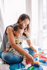 Mother playing with son at home