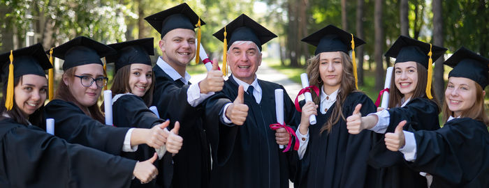 Portrait of friends wearing graduation