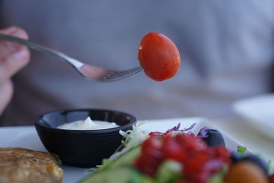 Close-up of tomatoes on fork over salad 