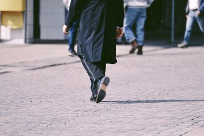 Low section of man walking on street