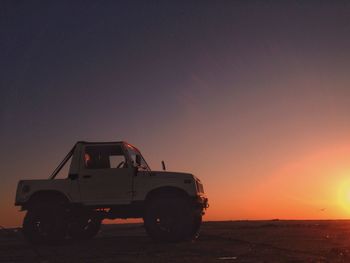 Vintage car on road against clear sky at sunset