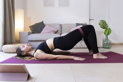 Young woman practicing exercise with resistance band