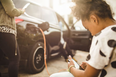 Girl using smart phone while sitting in yard